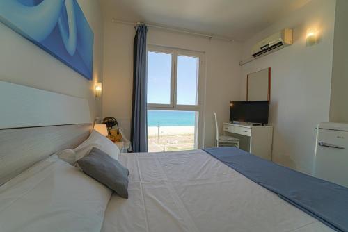 a bedroom with a bed with a view of the ocean at Hotel Rivabella in Davoli