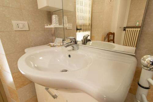 bagno con lavandino bianco e specchio di La Casa del Postino a Farigliano