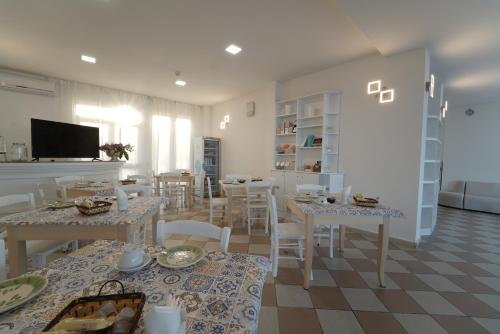 a dining room with white tables and white chairs at Hotel Rivabella in Davoli