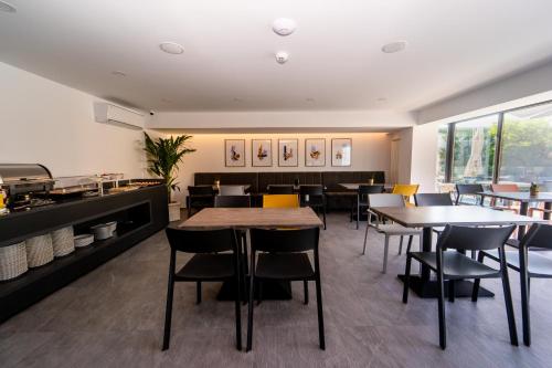 ein Esszimmer mit Tischen und Stühlen und eine Küche in der Unterkunft Hotel Vigo in Eforie Nord