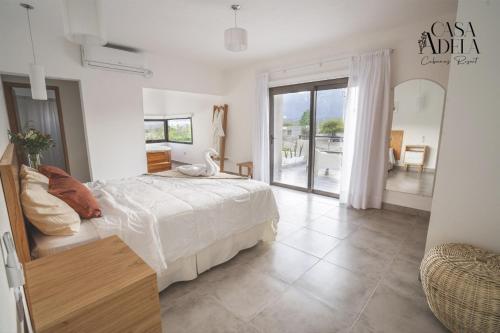 Habitación blanca con cama y balcón. en Casa Adela - Cabañas Resort en La Rioja