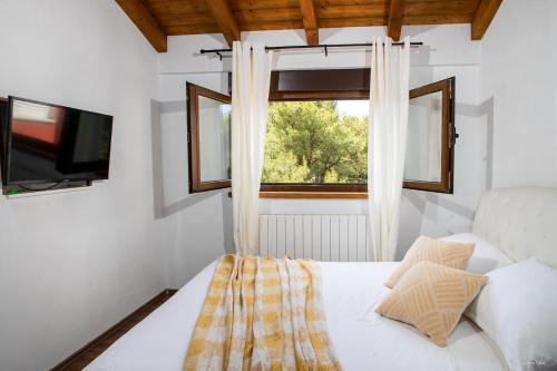 a bedroom with a bed with a window and a tv at Apartment "Istra Inspirita" in Rovinj