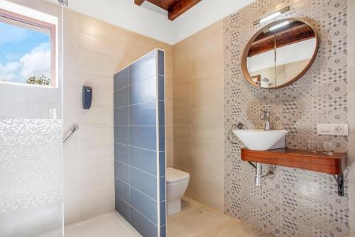 ein Badezimmer mit Toilette, Waschbecken und Spiegel in der Unterkunft Casa Domingo in Villaverde