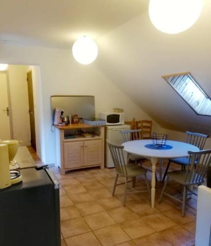 a kitchen and dining room with a table and chairs at La Miellerie du Massegros in Le Massegros