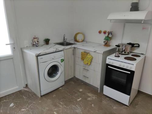 a kitchen with a washing machine and a sink at Διαμέρισμα κοντά στην θάλασσα in Arkoudi