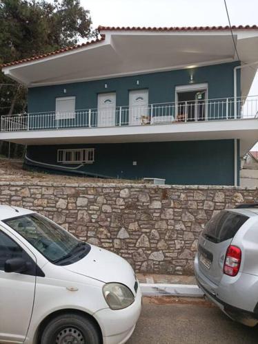 two cars parked in front of a house at Διαμέρισμα κοντά στην θάλασσα in Arkoudi