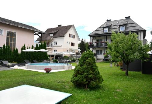 a yard with a house and a house at Enjoyit Rooms in Velden am Wörthersee