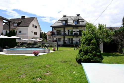 a yard with a house and a swimming pool at Enjoyit Rooms in Velden am Wörthersee