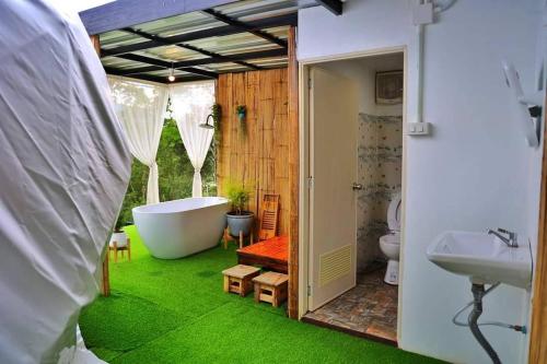 een badkamer met een bad, een toilet en een wastafel bij หุบเขาโฮมสเตย์ in Ban Kai Noi