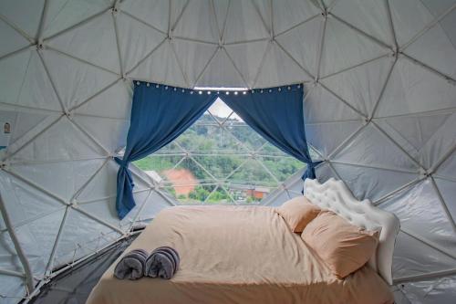 een bed in een koepeltent met een raam bij หุบเขาโฮมสเตย์ in Ban Kai Noi