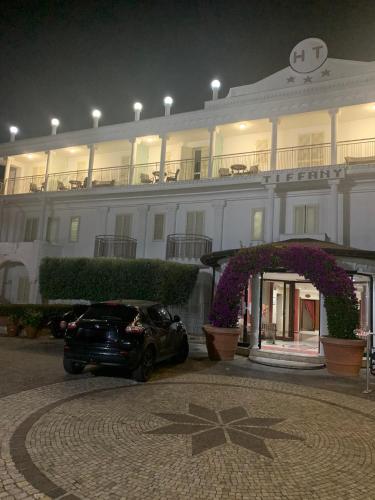 a car parked in front of a large building at Hotel Tiffany in Varcaturo