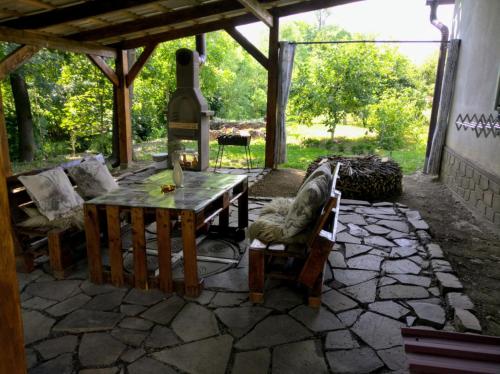a stone patio with a wooden table and chairs at Hotel Окремий Будинок-Апартаменти in Rakoshyno