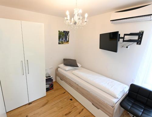 a room with a couch and a tv on the wall at Enjoyit Rooms in Velden am Wörthersee