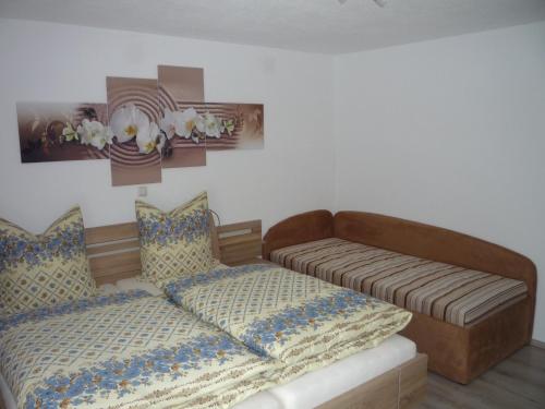a bedroom with a bed and a futon at Ferienwohnung Aletsee in Pfronten