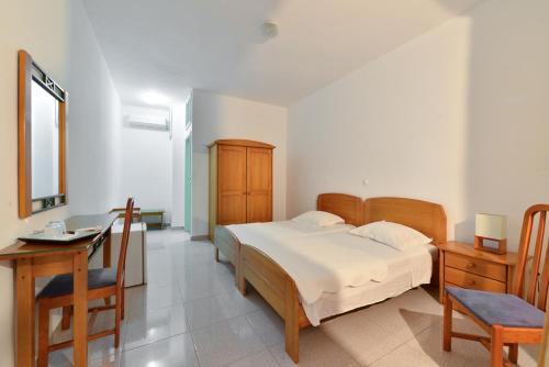 a bedroom with a bed and a table and a desk at Pousada Praia Maria in Praia