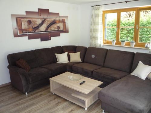 a living room with a brown couch and a coffee table at Ferienwohnung Aletsee in Pfronten