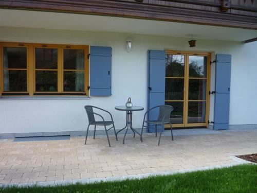 a patio with chairs and a table in front of a house at Ferienwohnung Aletsee in Pfronten