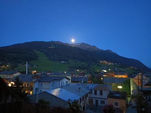 a view of a town with the moon on a mountain at Hotel Gufo in Bormio