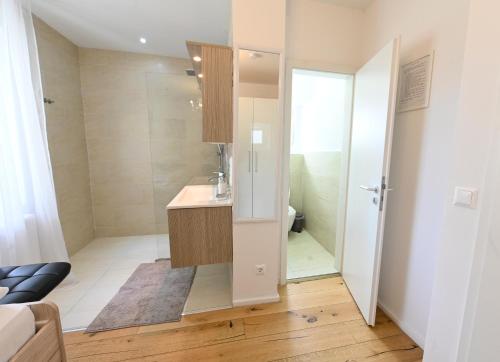 a small bathroom with a sink and a shower at Enjoyit Rooms in Velden am Wörthersee