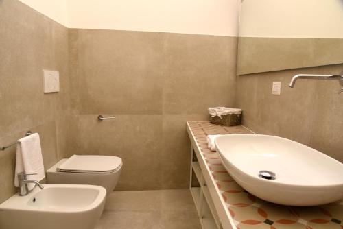 a bathroom with a white sink and a toilet at Li Frati Suite in Lecce