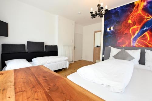 a bedroom with two beds and a wooden table at Enjoyit Rooms in Velden am Wörthersee