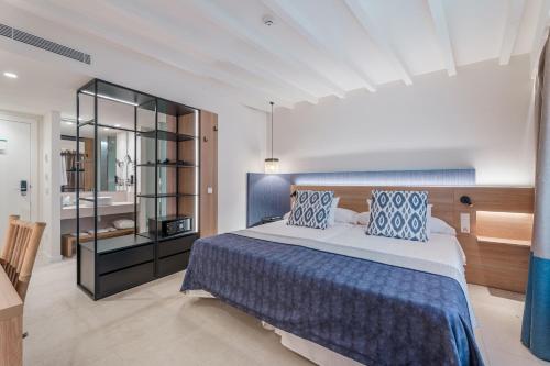 a bedroom with a large bed with blue pillows at Can Guixe - Turismo de Interior in Inca
