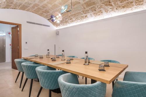 a conference room with a wooden table and blue chairs at Can Guixe - Turismo de Interior in Inca