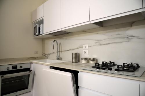 a white kitchen with a stove and a sink at Li Frati Suite in Lecce
