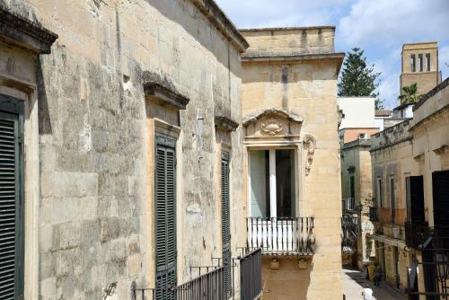 an old building with a balcony in a street at Li Frati Suite in Lecce