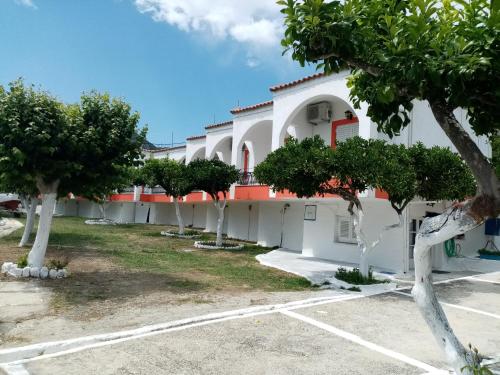 biały budynek z drzewami na parkingu w obiekcie Villa Nikitas w mieście Parga