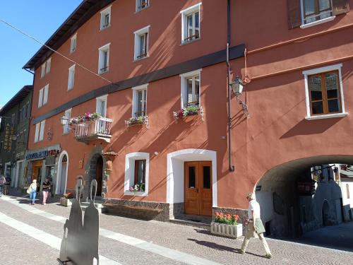 a person walking in front of a red building at Hotel Gufo in Bormio