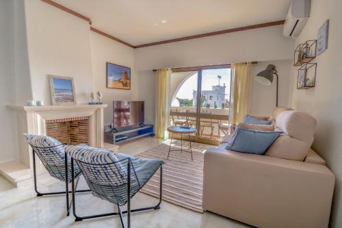 a living room with a couch and a fireplace at #007 Foxy W by Home Holidays in Albufeira