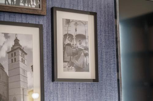 a framed picture of two women on a wall with a tower at Can Guixe - Turismo de Interior in Inca