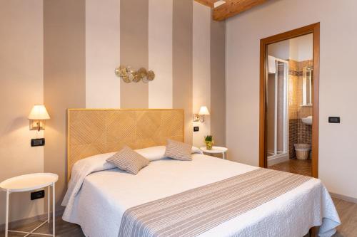 ルッカにあるB&B Stella Luccaのベッドルーム1室(白い大型ベッド1台、ストライプの壁付)
