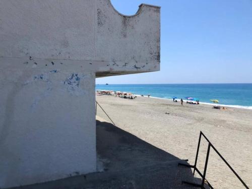 a stairway leading to a beach with people on the sand at Stella d'Aurora waterview in Belmonte Calabro
