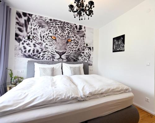 a bedroom with a bed with a picture of a leopard at Enjoyit Rooms in Velden am Wörthersee