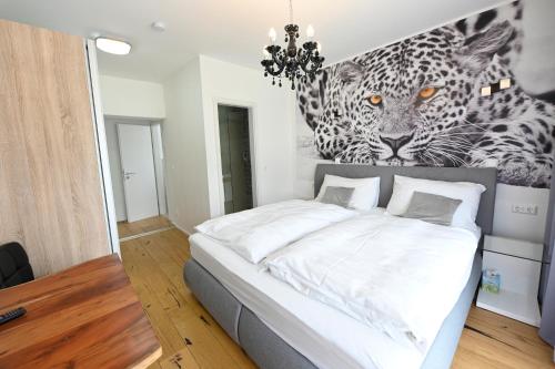 a bedroom with a bed with a painting of a leopard at Enjoyit Rooms in Velden am Wörthersee