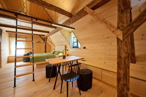 a wooden cabin with a desk and a bed in a room at NATUR BAJTA in Solčava