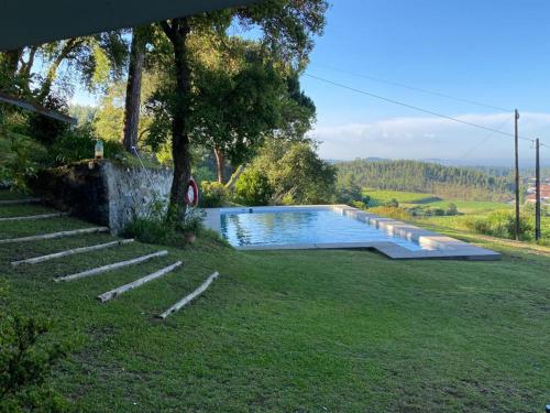 una piscina in un cortile con un albero di Lovely 6-Bed Cottage in Barcelos - Vila Cova a Barcelos