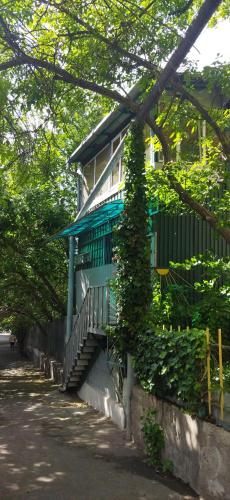 a house with a blue railing and stairs next to a street at Asine Yerevan in Yerevan