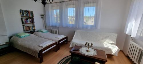 a room with two beds and a table and a book shelf at U Tereni na Mazurach in Kuty