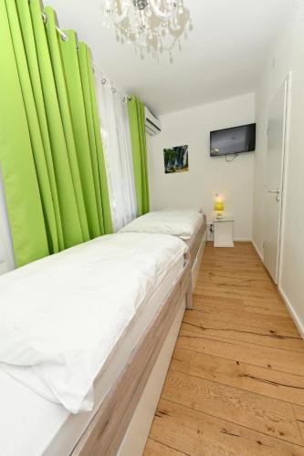a bedroom with green curtains and a large bed at Enjoyit Rooms in Velden am Wörthersee