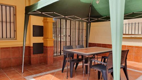 - une table et des chaises sous un parasol dans une chambre dans l'établissement Villa de Islantilla, à Islantilla