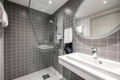 a bathroom with a sink and a mirror at Quality Hotel Grand Larvik in Larvik
