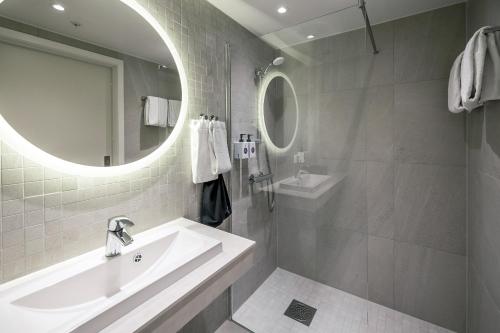 a bathroom with a sink and a mirror at Quality Hotel Grand Larvik in Larvik