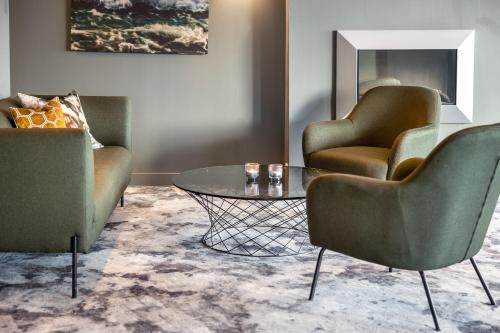 a living room with two chairs and a glass table at Quality Hotel Grand Larvik in Larvik