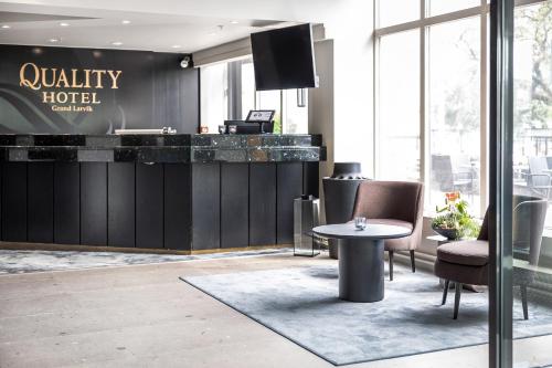 a lobby of a hotel with a table and chairs at Quality Hotel Grand Larvik in Larvik