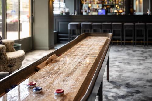 a wooden table in a room with a bar at Quality Hotel Grand Larvik in Larvik