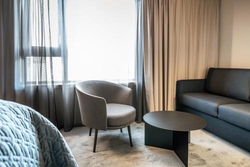 a hotel room with a bed and a chair and a couch at Quality Hotel Grand Larvik in Larvik