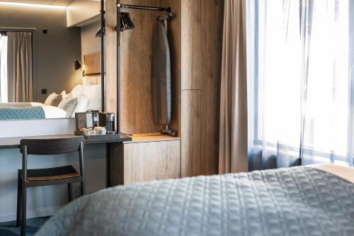 a hotel room with a bed and a desk with a mirror at Quality Hotel Grand Larvik in Larvik